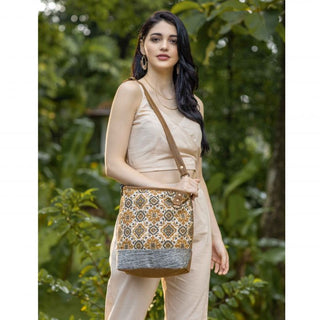 Patterned bag with brown strap and gray base on a white background