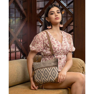 Crossbody bag with gray and white patterned design and brown leather accents on a white background