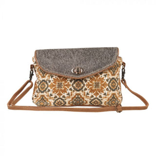 Flap-over handbag with patterned front and gray top, on a white background