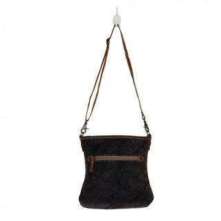 Patterned handbag with brown leather accents on a white background