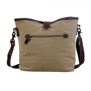 Multicolored striped bucket bag with brown leather accents on a white background