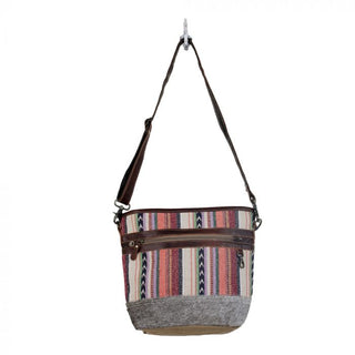 Multicolored striped bag with a gray base and brown straps on a white background